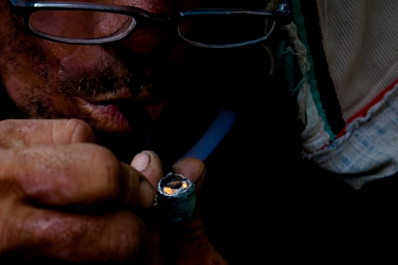 usuário de droga fumando uma pedra de crack