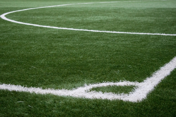 gramado de futebol, com as linhas de escanteio e da grande área caiadas de branco