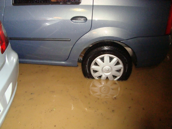 Detalhe garagem alagas, com dois veículos com as rodas sob a água
