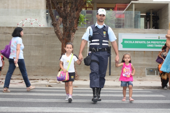 Guarda Municipal ajudando duas crianças a atravessar a rua