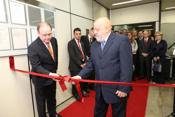 Presidente do TRE-MG, Edgard Amorim, e presidente da Câmara, Henrique Braga, sobre tapete vermelho, abrindo laço de fita vermelha que atravessa o corredor