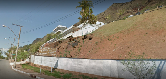 vista panorâmica da fachada do antigo hospital Hilton Rocha e parte da Serra do Curral. Placa sinaliza a área como patrimônio ambiental