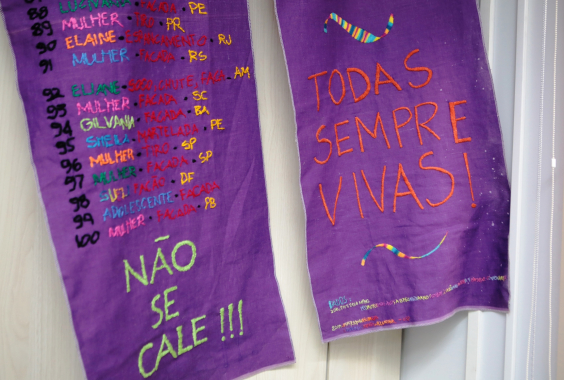 Bordado com nomes de mulheres mortas por feminicídio. Com as inscrições "Não se cale" e "Todas sempre vivas"