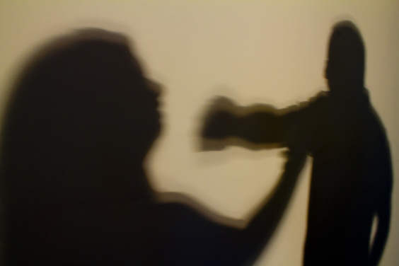 sombra mostra a silhueta do rosto de uma mulher próximo ao punho cerrado de um homem
