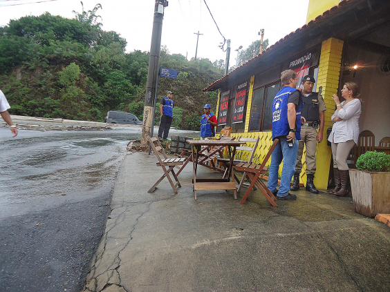 foto mostra fiscais da Prefeitura durante abordagem a bar com mesas na calçada