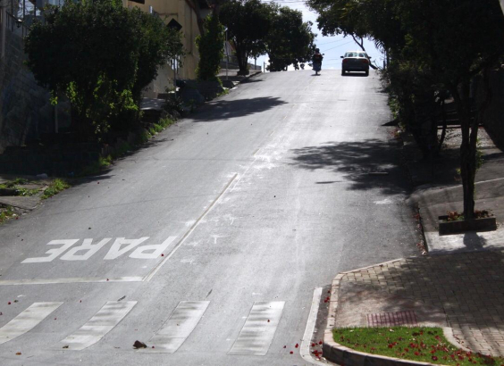Imagem de rua asfaltada com declividade acentuada