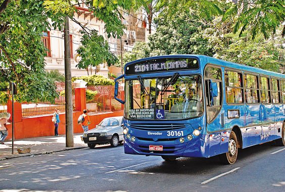 ônibus azul com os dizeres "2014 Fac Milton Campos" circula na cidade ,durante o dia. 