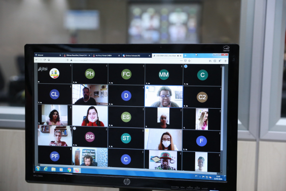 Dez pessoas, entre homens e mulheres, participam de reunião virtual na tela de um computador