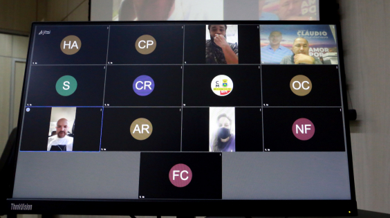 Uma vereadora e três vereadores na tela de um computador, realizando reunião remota.