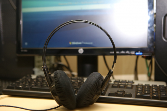 Fone de ouvido em frente a uma tela de computador