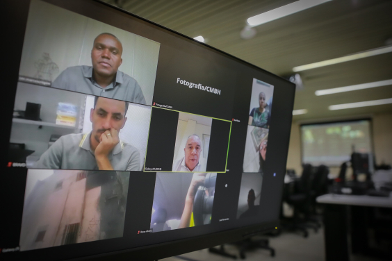 Sete pessoas participam de reunião remota, exibida em tela de computador. 