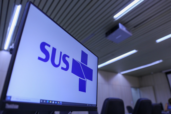 Na tela do computador, o símbolo do Sistema Único de Saúde (SUS) em azul com fundo branco