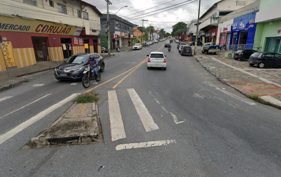 Rua de mão dupla com sinalização falha de faixa de pedestre, durante o dia.