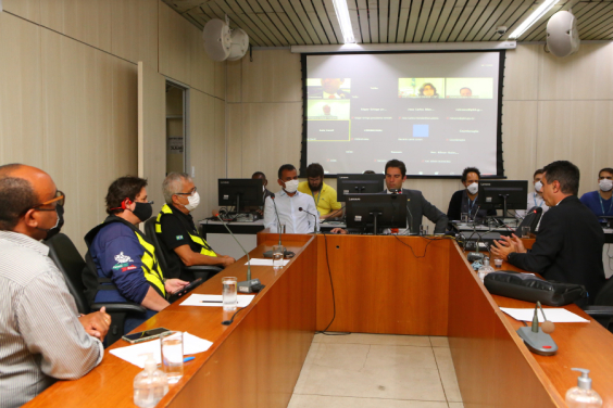 Os vereadores Wesley e Braulio em sala de reunião, acompanhados de quatro cidadãos, todos sentados à mesa e com máscara.