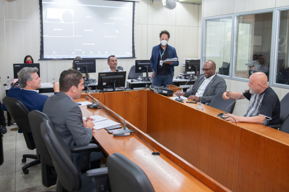 Cinco vereadores sentados à mesa, acompanhados por três assessores da Câmara. 