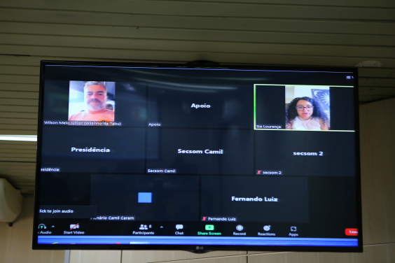 Homem e mulher em tela de computador, participando de reunião remota.