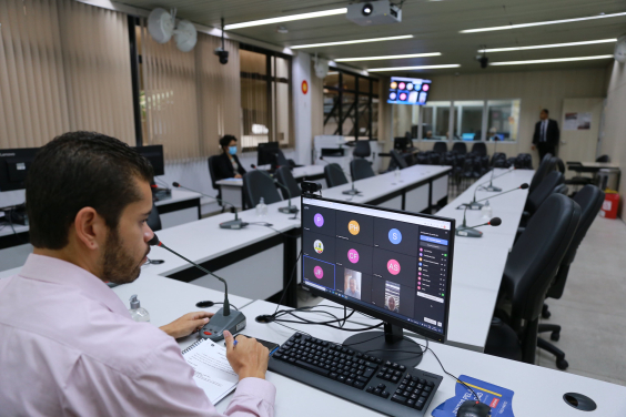 Sentado em frente a computador, assessor da Câmara acompanha reunião virtual com quatro vereadores.