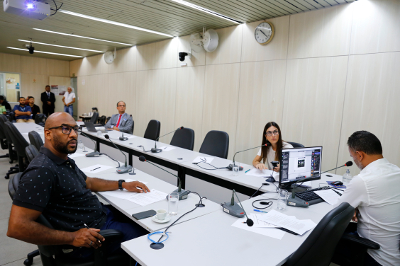 Três parlamentares e um advogado em reunião, sentados à mesa.