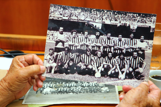 Foto mostra mãos segurando foto antiga de clube de futebol
