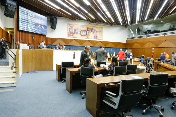 imagem do Plenário Amynthas de Barros. Ao fundo, a mesa diretora e em primeiro plano as cadeiras dos parlamentares