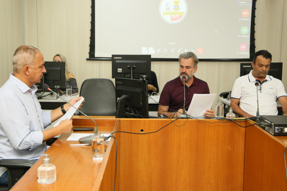 Três parlamentares reunidos, sentados à mesa.