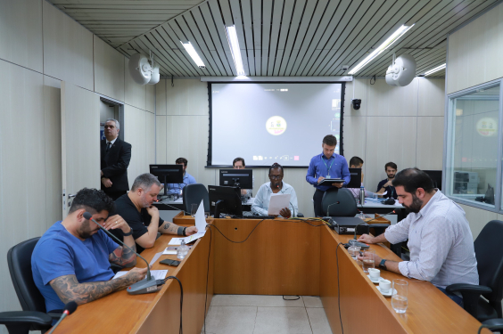 Quatro parlamentares sentados à mesa, em reunião.