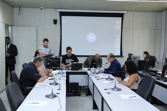 Seis parlamentares em reunião, sentados à mesa.