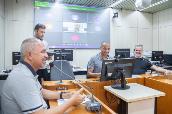 Três parlamentares reunidos, sentados à mesa.