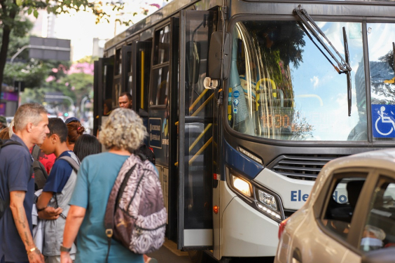 imagem da frente de um ônibus com pessoas entrando e em pé na porta