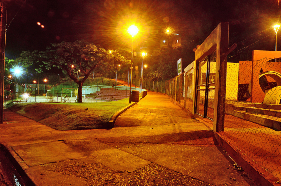 Rua da cidade durante o período noturno, com postes de iluminação