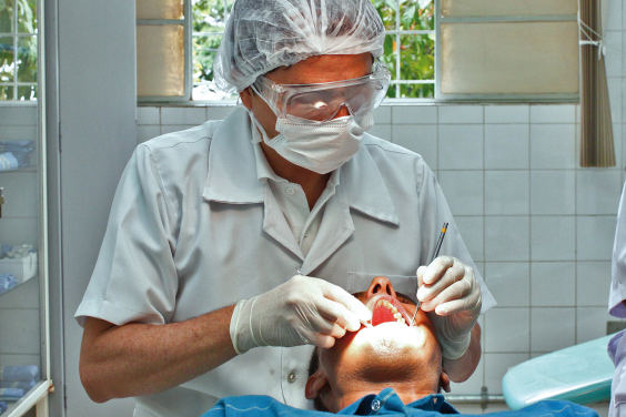 profissional de saúde bucal realiza atendimento em paciente