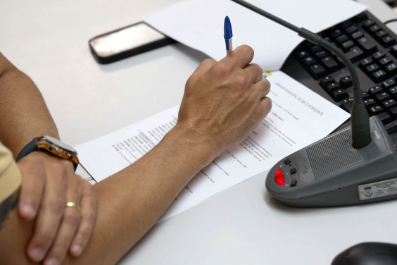 close em mãos segurando caneta em cima de documento de papel