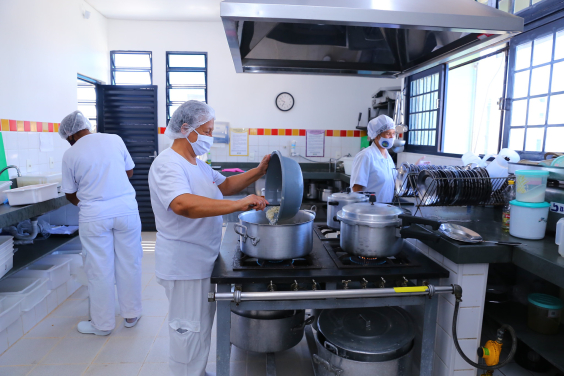 Mulheres preparam merenda em cantina escolar