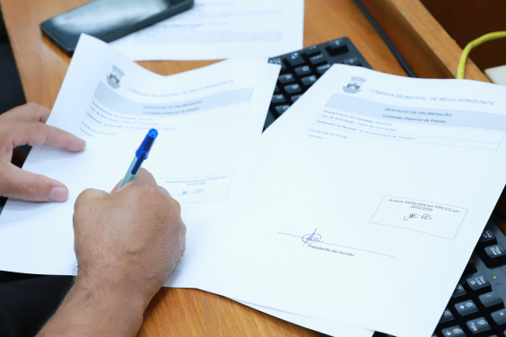 close em mãos de parlamentar assinando papel