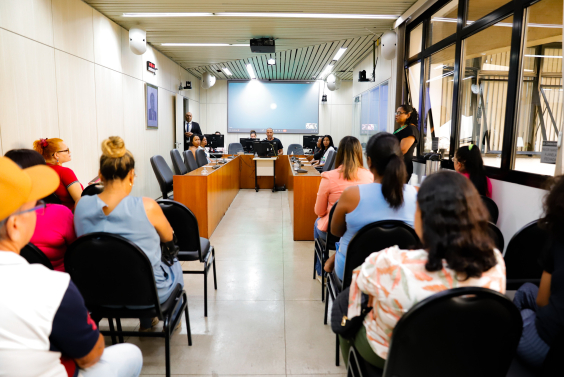 Moradores de costas para a câmera, voltados para mesa de audiência pública no plenário da CMBH