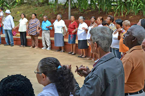 grupo de idosos em roda dando as mãos
