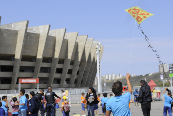 Menino empinando pipa em frente ao Mineirão