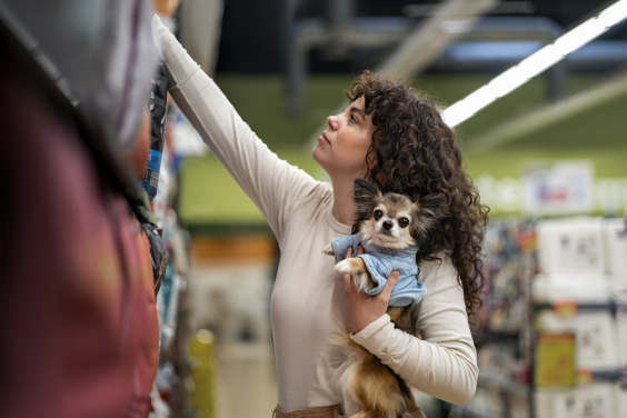 mulher segura cachorro de estimação dentro de supermercado