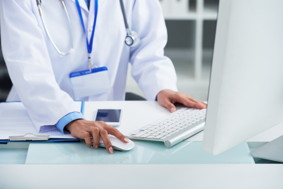 Mãos de médico usando computador enquanto trabalha