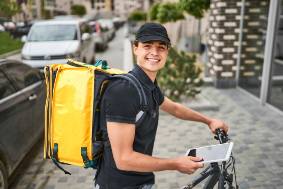 Entregador sorridente em bicicleta com tablet