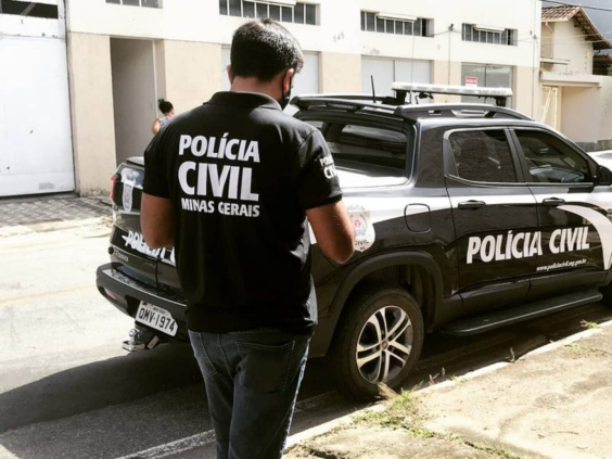 agente da polícia civil ao lado de veículo da corporação