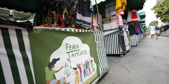 Barraca de feira, com roupas à venda, vista de baixo para cima