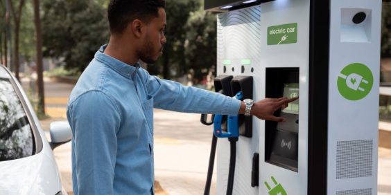 homem utiliza terminal de carga de veículo