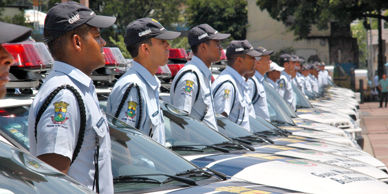 Guardas em fila com viaturas policiais