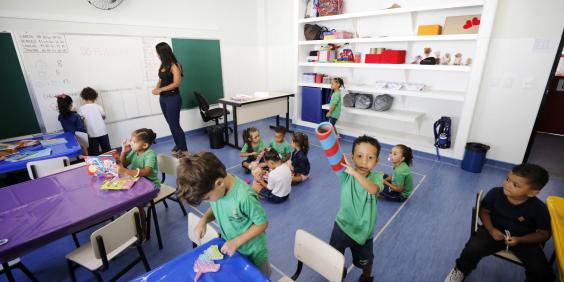 Crianças brincam dentro de sala de aula