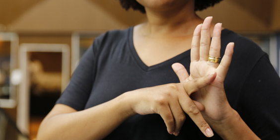 Pessoa faz sinal de Libras com as mãos