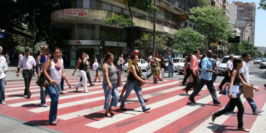 Pedestre atravessando faixa em avenida movimentada