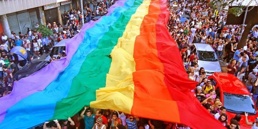 Militantes do movimento GLBT carregam bandeira do arco-íris, símbolo da causa
