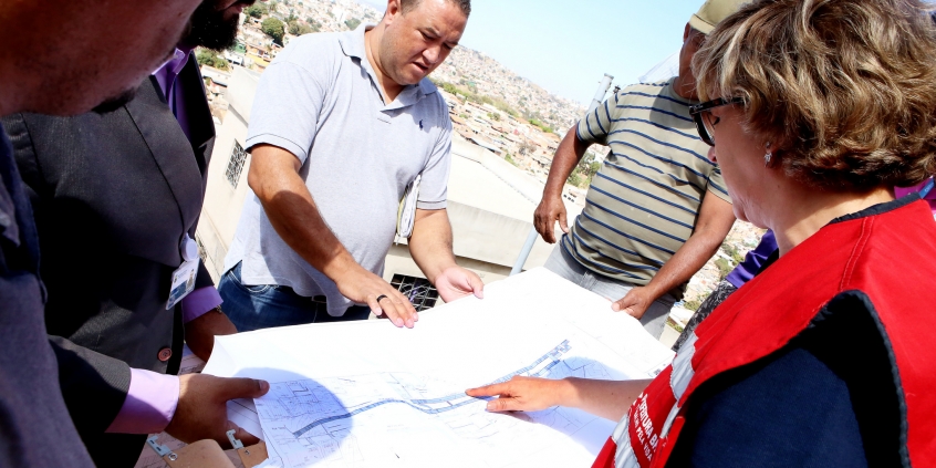 Vereador branco analisa um pepel branco, que contem mapa e projeto técnico de obra no bairro Vila do Sol