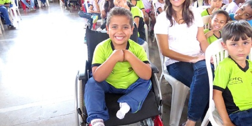 criança com deficiência em atividade junto com outras crianças em escola pública